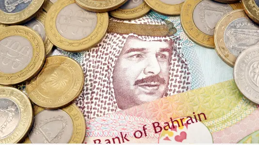 An image of Bahraini dinar banknote with some coin above it