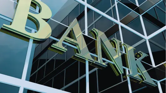 A closeup image of a bank, focused on a reflective signage labeled "Bank"