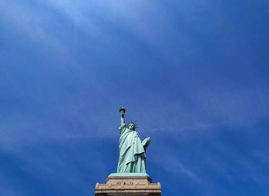 An image of the Statue of Liberty in New York with a blue sky in the background