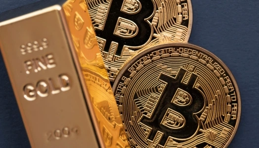 An image of two units of Bitcoin and a bar of fine gold to represent different financial assets