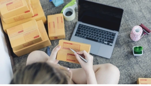 An image of a person packing an online order from selling it online